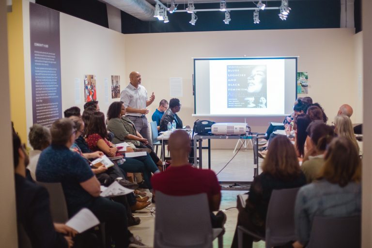 A large group of people listening to a presentation