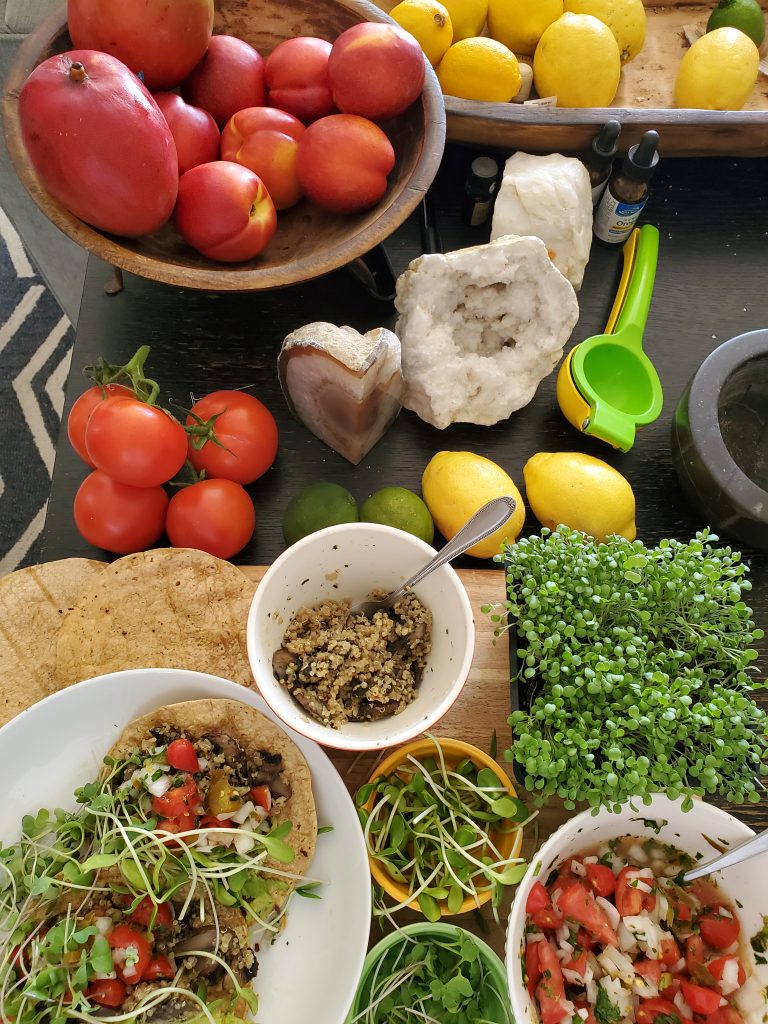 A table of fresh fruits and vegetables, including tomatoes, limes, and lemons